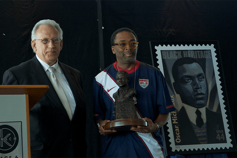 A black man holding an award